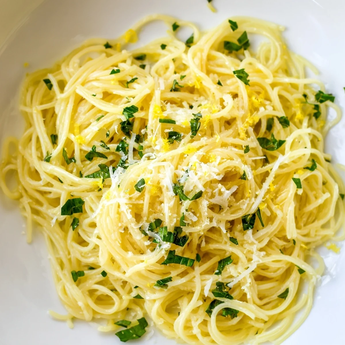 Vibrant plate of Lemon Capellini with fresh herbs, showcasing the zesty flavors and texture.