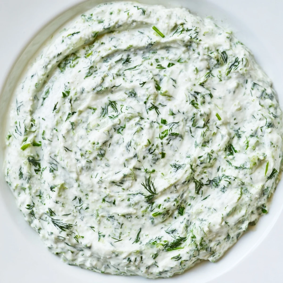 Vibrant green herbs blend with tangy Greek Yogurt Herb Dip, perfect for dipping or spreading on a sandwich.