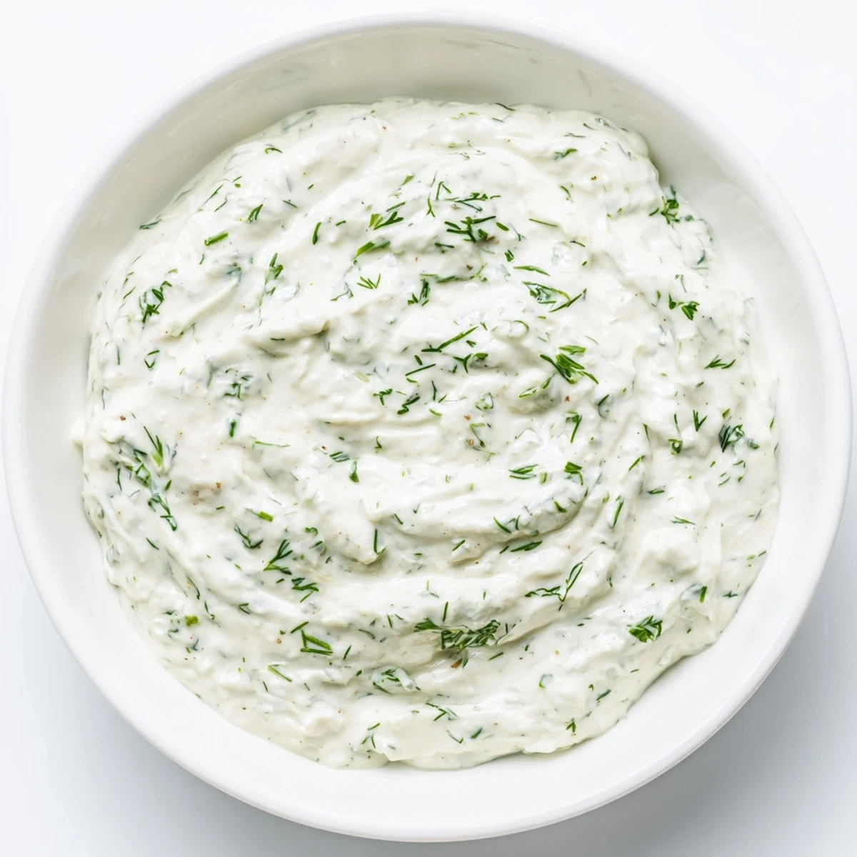 Creamy Greek Yogurt Herb Dip, speckled with fresh herbs, is ready to be scooped with crisp veggies.