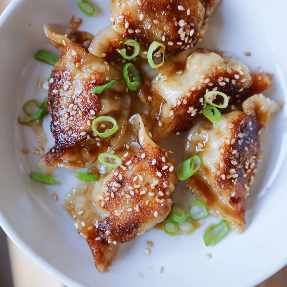 Air Fryer Frozen Dumplings: crispy golden brown dumplings ready to be glazed with sesame oil for your plate.