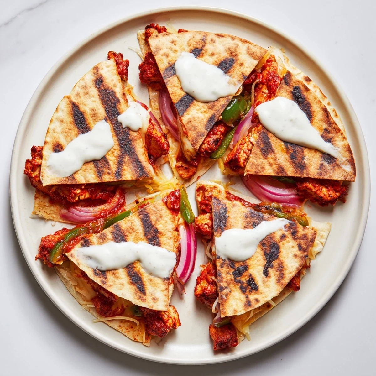 Golden-brown tandoori chicken quesadilla, showing melted cheese oozing with savory, spiced chicken filling and veggies.