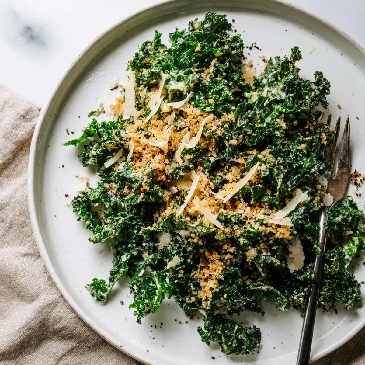 Crisp massaged kale tossed with creamy garlic-Parmesan dressing, topped with golden toasted breadcrumbs in a rustic bowl.  