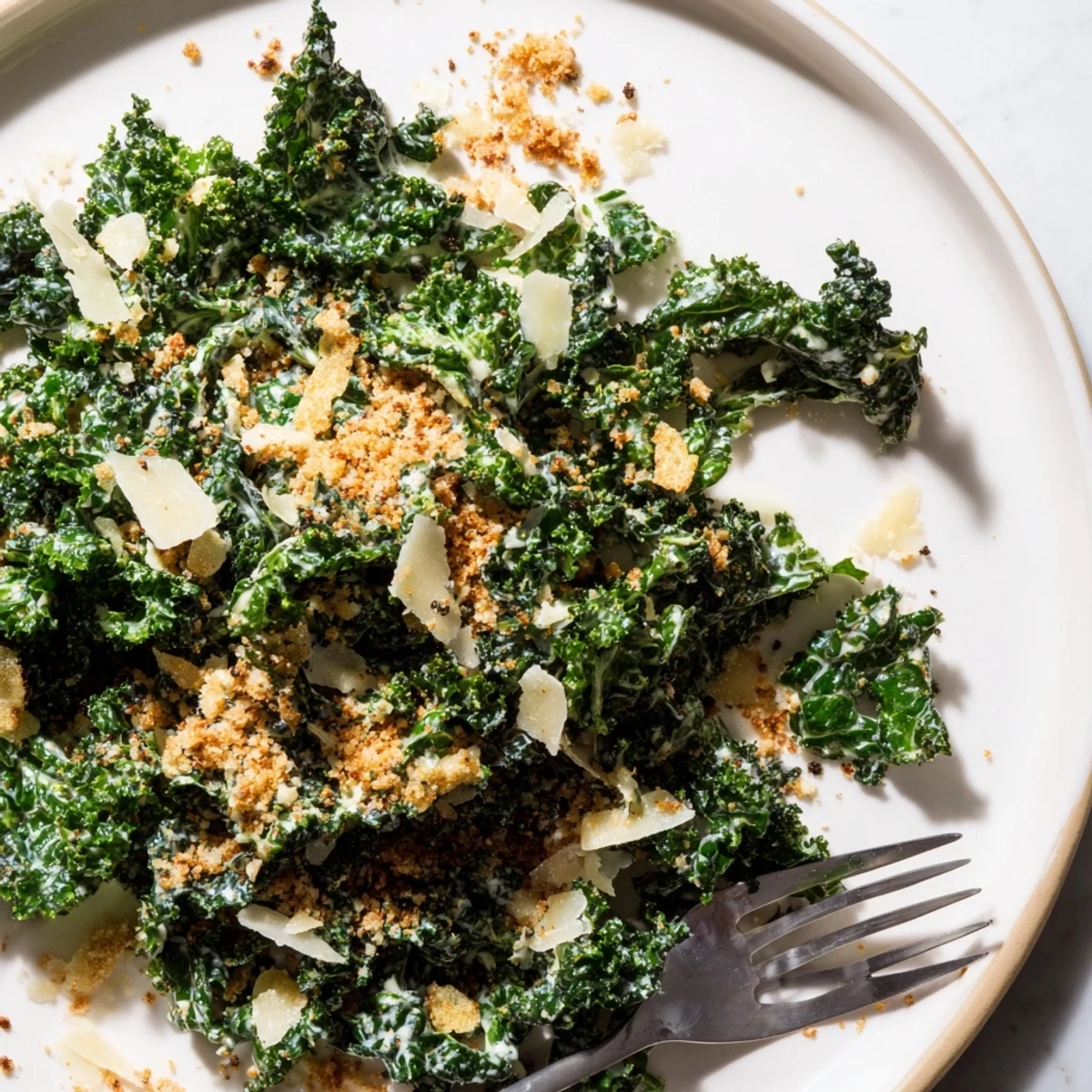 Fresh kale leaves coated in a tangy garlic-Parmesan sauce, complemented by crunchy toasted breadcrumbs for a satisfying texture.