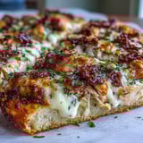 Overhead view of Marry Me Chicken pizza with melted mozzarella, garlic, and rich Parmesan cream sauce bubbling. 