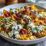 Creamy avocado ranch coats rotini pasta, black beans, and fresh vegetables in this Doritos-topped Taco Pasta Salad.  