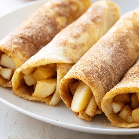 Warm, flaky Apple Pie Roll-Ups with a sweet cinnamon sugar crust, perfect for a quick dessert.