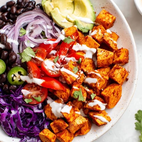A delicious close-up of a fully assembled Sweet Potato Taco Bowl with fresh lime garnish.