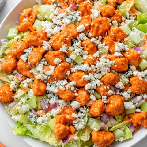 Tender buffalo chicken pieces are tossed with diced celery and red onion in a hearty chopped salad.