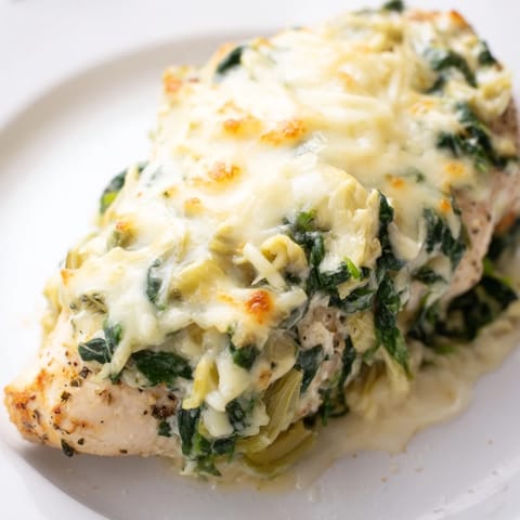 Tender chicken breasts are smothered in a creamy, tangy spinach and artichoke yogurt blend in this comforting dish.