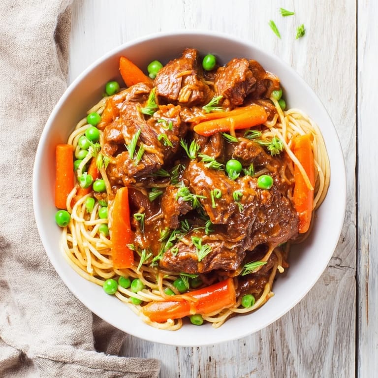 A steaming bowl of Skillet Beef Stir-Fry, with savory sauce glistening over crisp snap peas and carrots.