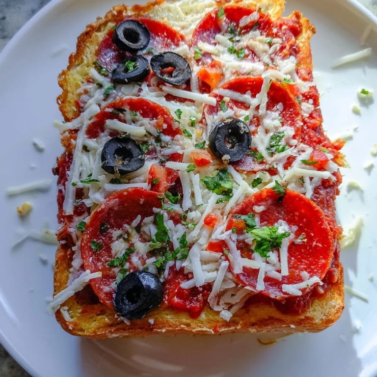 Golden-brown Air Fryer Pizza Toast, with bubbling cheese and crispy edges, ready to serve as a quick meal.