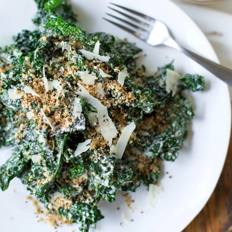 Garlic Parmesan Kale Salad served as a vibrant side, garnished with shaved Parmesan and a twist of black pepper.  